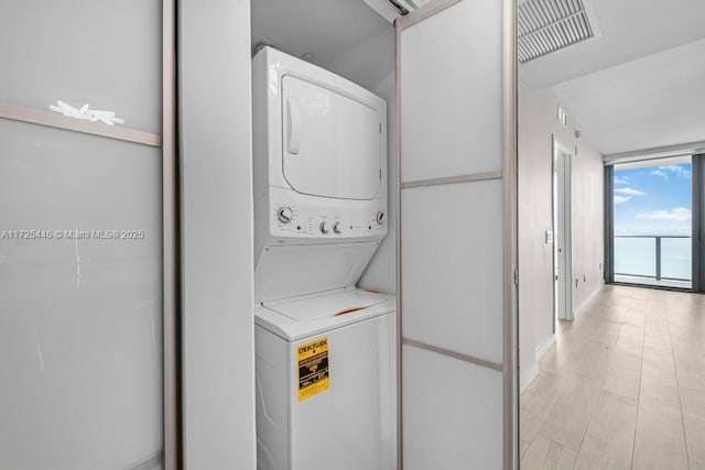 washroom featuring stacked washer / dryer