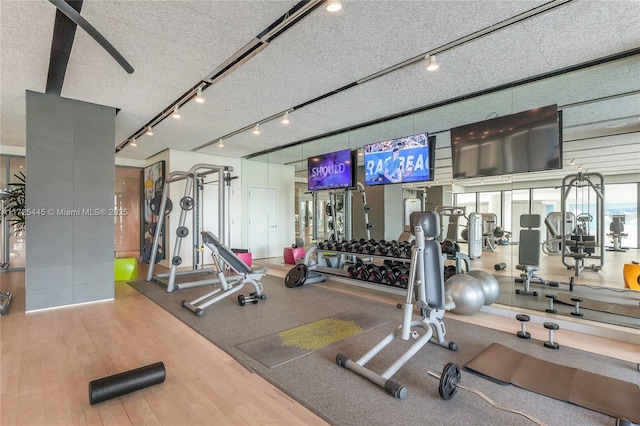 gym with wood-type flooring and a textured ceiling