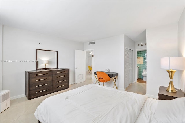 bedroom with ensuite bathroom, a closet, and light tile patterned floors