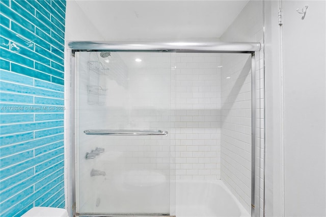 bathroom with shower / bath combination with glass door