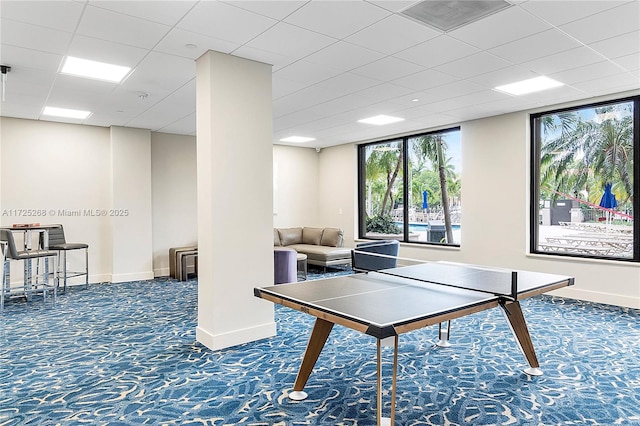 game room featuring a paneled ceiling and dark carpet