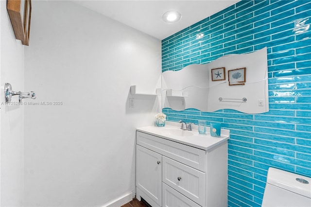 bathroom with tile walls, vanity, and toilet