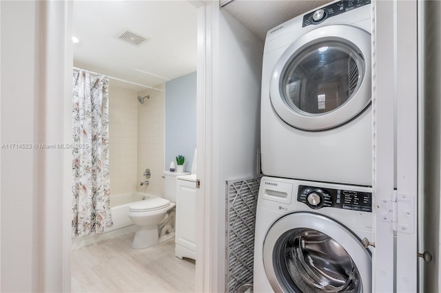 laundry area featuring stacked washing maching and dryer