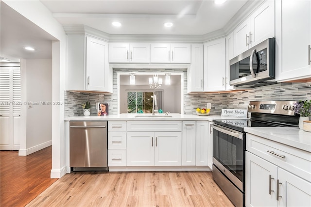 kitchen with appliances with stainless steel finishes, sink, and white cabinets