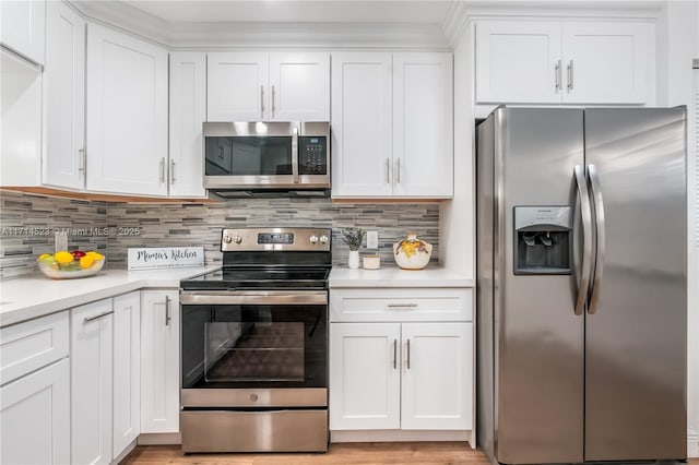 kitchen with tasteful backsplash, appliances with stainless steel finishes, and white cabinets