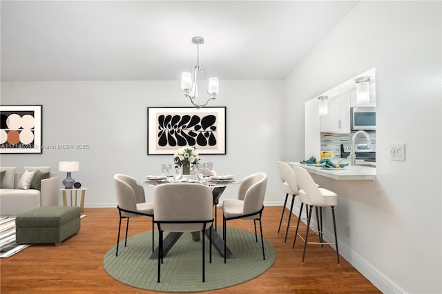 dining space with a chandelier and light hardwood / wood-style flooring