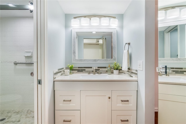 bathroom featuring vanity, backsplash, and tiled shower