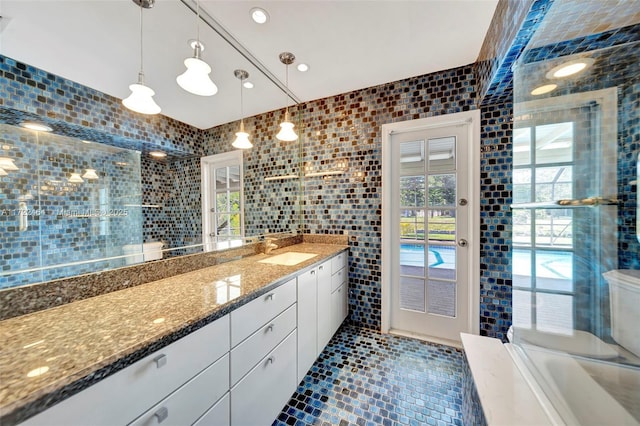 bathroom with tile walls, tile patterned flooring, vanity, and toilet