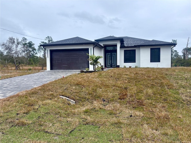 view of front of home with a front yard and a garage