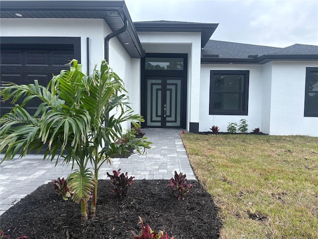 entrance to property featuring a lawn and a garage