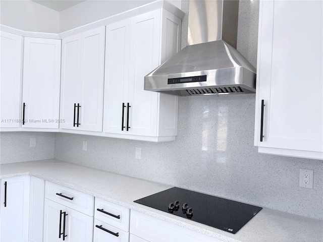 kitchen featuring white cabinets, black electric stovetop, backsplash, and wall chimney exhaust hood