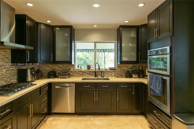 kitchen with sink, stainless steel appliances, wall chimney range hood, and backsplash