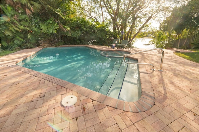 view of swimming pool featuring an in ground hot tub and a patio