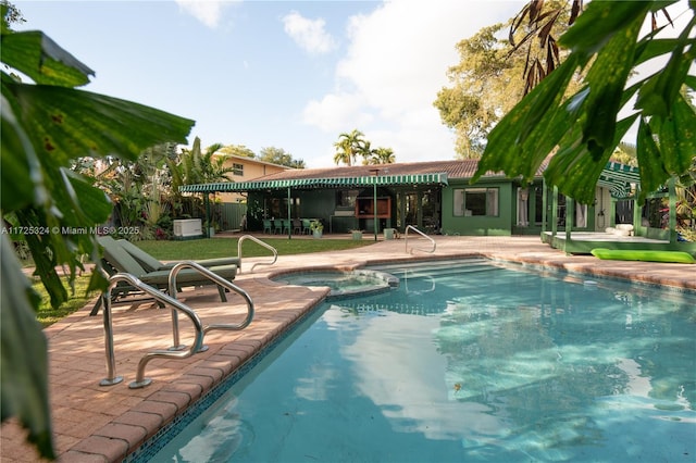 view of swimming pool with a patio and an in ground hot tub