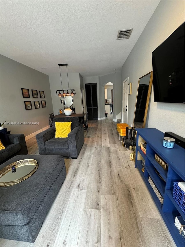 living room featuring a textured ceiling and light hardwood / wood-style floors