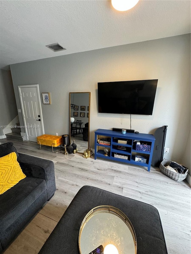 living room featuring a textured ceiling and hardwood / wood-style floors