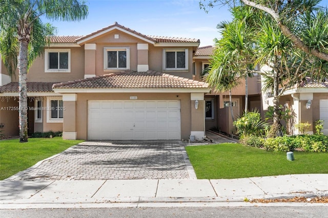 mediterranean / spanish house featuring a front yard and a garage