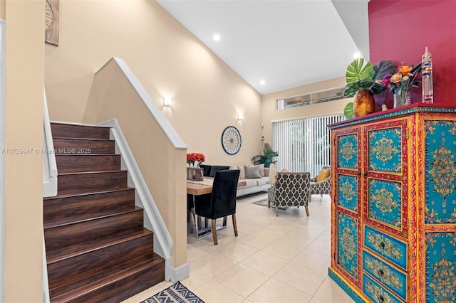 staircase featuring a towering ceiling and tile patterned flooring