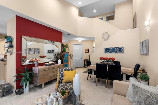 living room featuring a towering ceiling and light tile patterned flooring