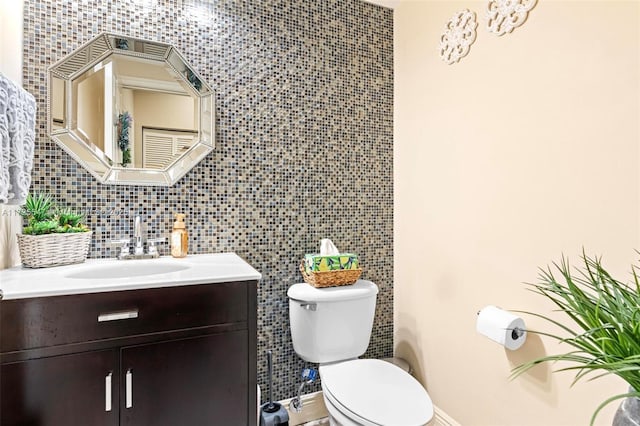 bathroom featuring toilet, vanity, tile walls, and tasteful backsplash