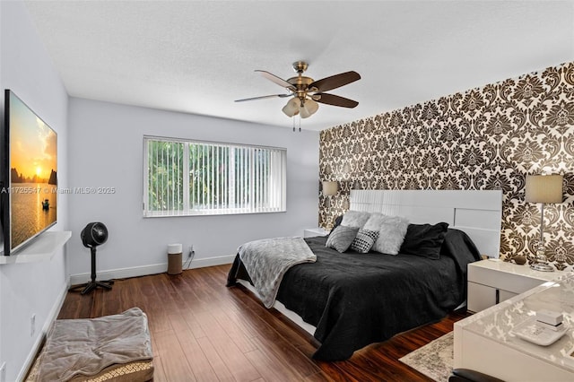 bedroom with dark wood-type flooring, a textured ceiling, and ceiling fan