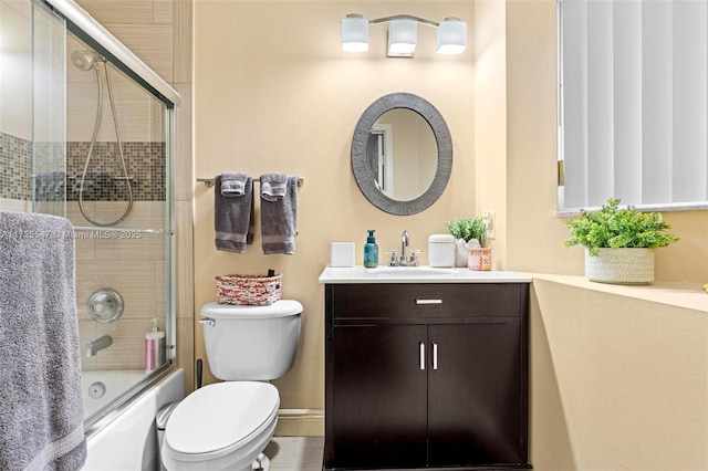 full bathroom featuring toilet, vanity, and bath / shower combo with glass door