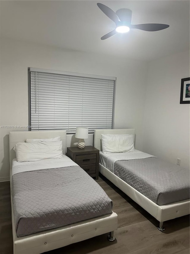 bedroom with dark hardwood / wood-style flooring and ceiling fan