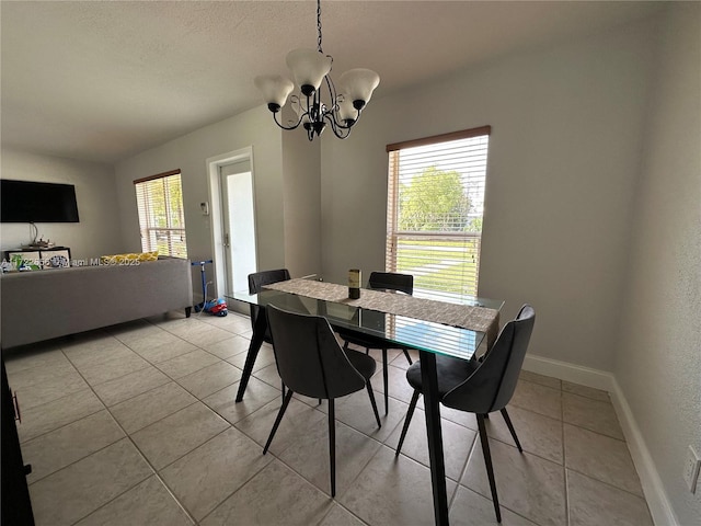 dining area with a chandelier, light tile patterned flooring, and a wealth of natural light