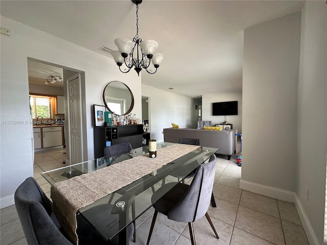 dining area with sink, a chandelier, and light tile patterned floors