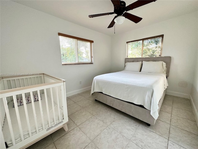 bedroom with ceiling fan, multiple windows, and light tile patterned floors