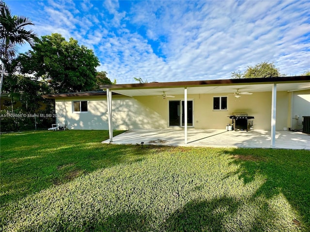 rear view of house featuring ceiling fan, a patio, central air condition unit, and a lawn