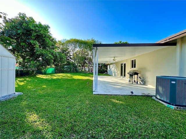 view of yard featuring central AC, ceiling fan, and a patio