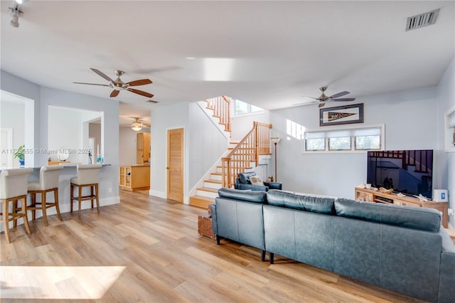 living room featuring ceiling fan and light hardwood / wood-style floors