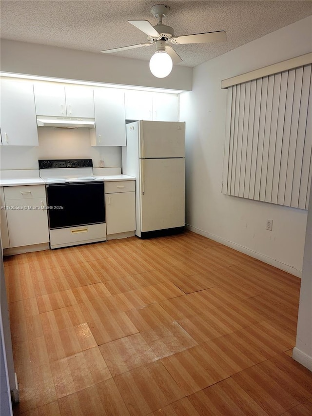 kitchen with white fridge, electric range, a textured ceiling, and white cabinetry