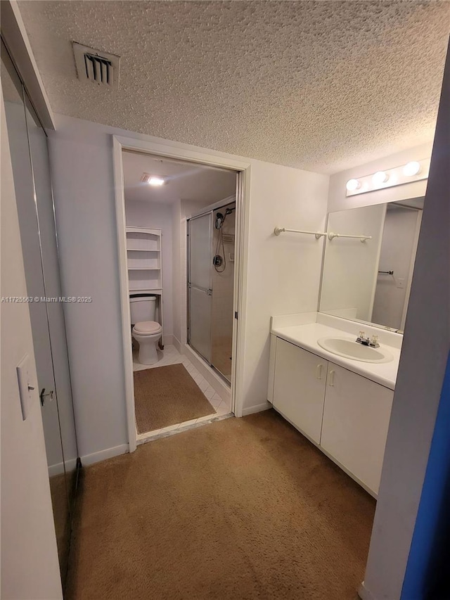 bathroom with vanity, a textured ceiling, and a shower with shower door