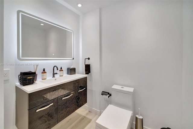 bathroom with vanity, toilet, and wood-type flooring