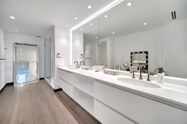 bathroom with vanity, wood-type flooring, and walk in shower