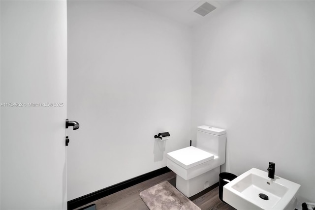 bathroom featuring a bidet, sink, hardwood / wood-style floors, and toilet