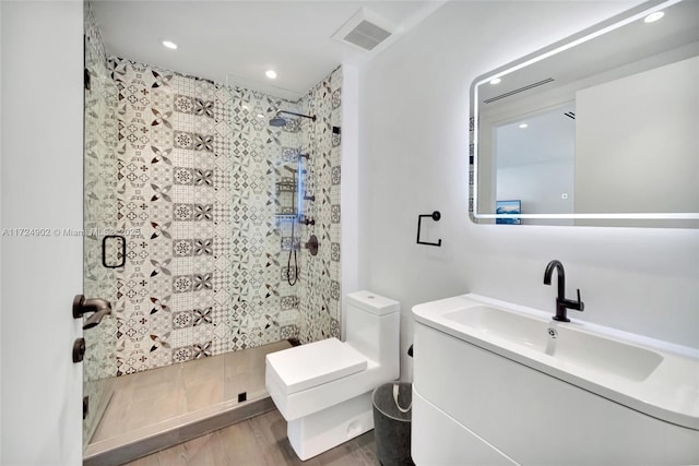 bathroom featuring vanity, toilet, and a shower with shower door