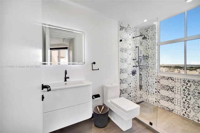 bathroom with vanity, toilet, and a tile shower