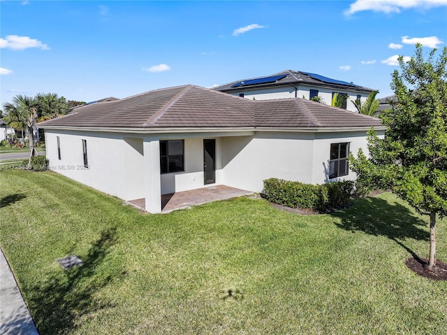 back of property with a lawn and a patio area