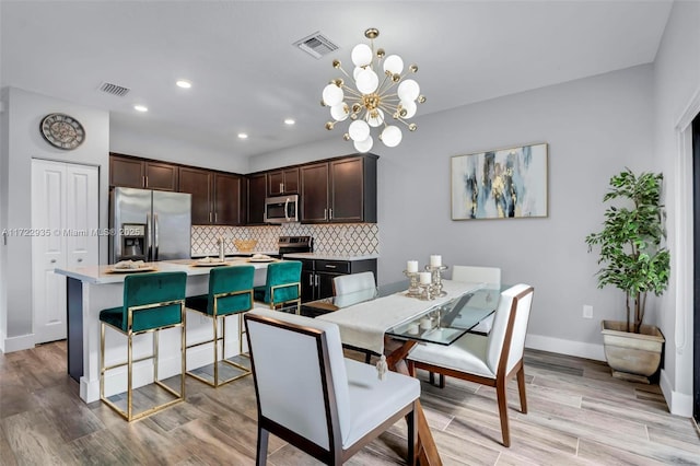 dining room with a chandelier and light hardwood / wood-style flooring