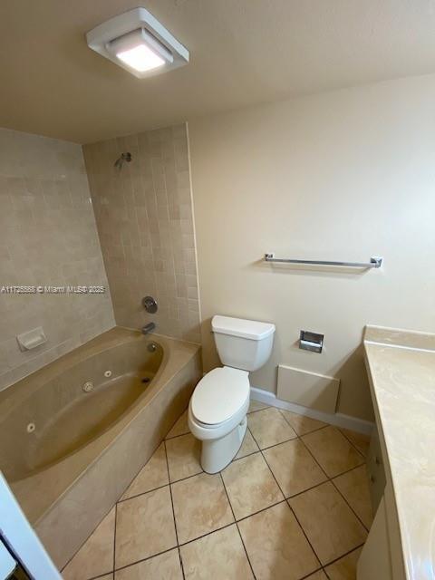 full bathroom with vanity, tiled shower / bath, tile patterned floors, and toilet