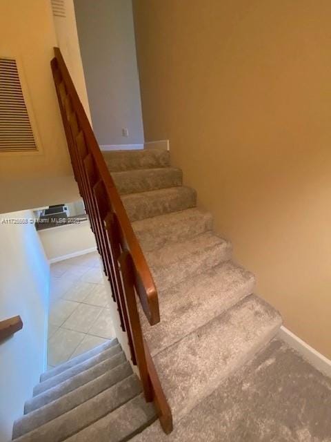 stairway with tile patterned flooring