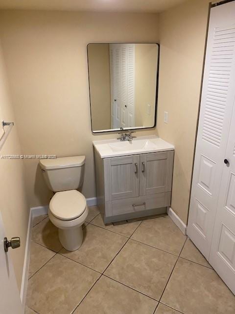 bathroom featuring toilet, tile patterned flooring, and vanity