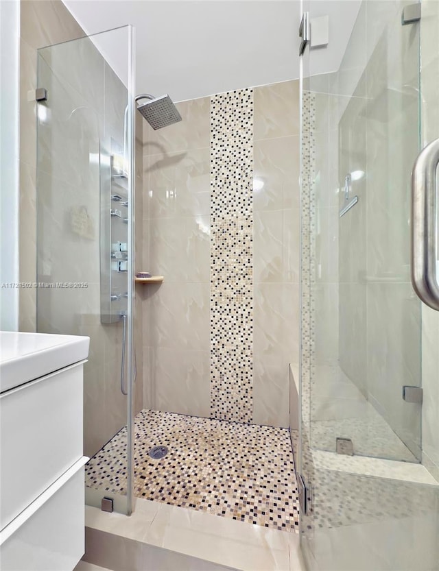 bathroom featuring walk in shower and vanity