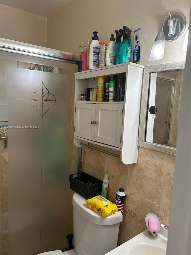 bathroom featuring toilet, tile walls, and tasteful backsplash