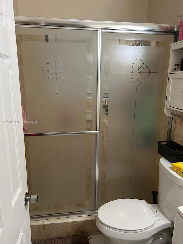 bathroom with toilet, tile patterned flooring, a shower with shower door, and vanity