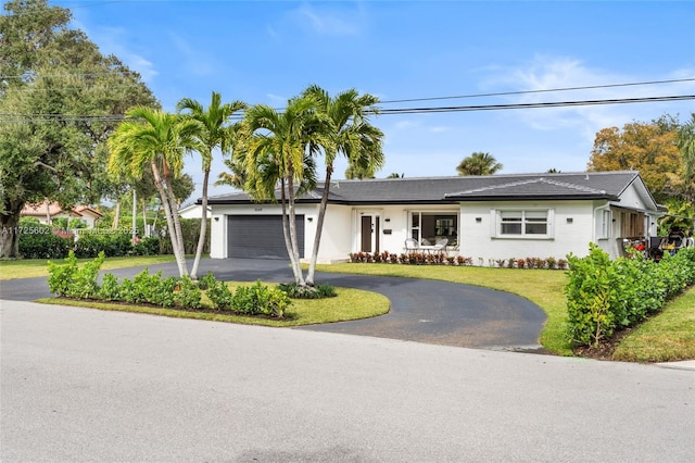 single story home with a front yard and a garage