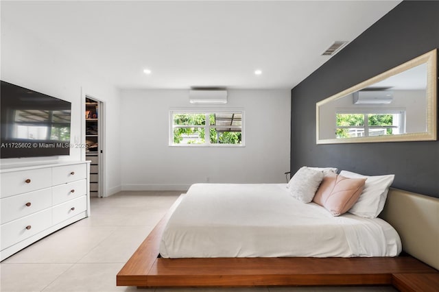 bedroom with light tile patterned flooring, multiple windows, and a wall mounted air conditioner